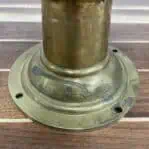 Close-up of weathered brass base with signs of patina and age