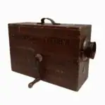 Front view of vintage rotary foghorn showing the hand crank and worn wood surface.