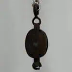 single sheave wood block pulley hanging against white wall
