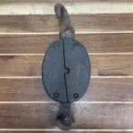 close-up of cracked wooden pulley face with metal hook