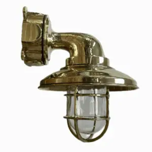 Brass nautical wall sconce mounted overhead with clear globe and cage