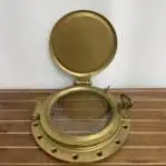 Iron ship porthole with open cover revealing clear glass