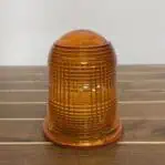 Orange ribbed lens from brass nautical ceiling light – close-up