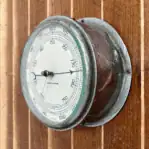Kelvin Hughes Marine Barometer mounted on wood showing worn chrome housing and cream dial