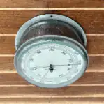 Kelvin Hughes Marine Barometer front view on wood panel showing outer-ring numbers and aged chrome finish