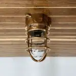 Side view of brass nautical ceiling fixture with junction box opening