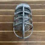 Front cage view of vintage aluminum nautical bulkhead light