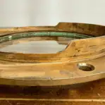 Inset Close-Up on Asymmetrical Red Brass Porthole Frame