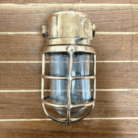 Pauluhn Salvaged Brass Bulkhead Light Front view of salvaged light with cage and glass globe
