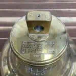 salvaged nautical brass bell top view with manufacturer plaque and mounting bracket