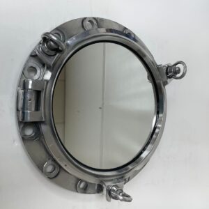 Ship porthole mirror mounted on wall showing aluminum frame and three dog locking handles