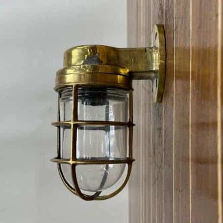 Brass Nautical Wall Light with Cage and Glass Globe 03 brass nautical wall light mounted on wall showing side angle