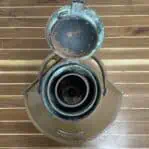 Top view of vintage copper ship lantern with open lid showing patina and oil chamber