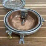 Interior view of vintage aluminum bulkhead light showing copper base and rewiring
