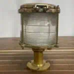 Side angle of NEON-VRSAR brass navigation light on wood background