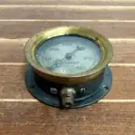 Close-up of gauge showing threaded bottom fitting and worn metal base.