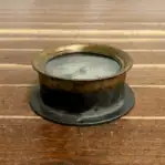 top view of an aged gauge resting on a wood surface.