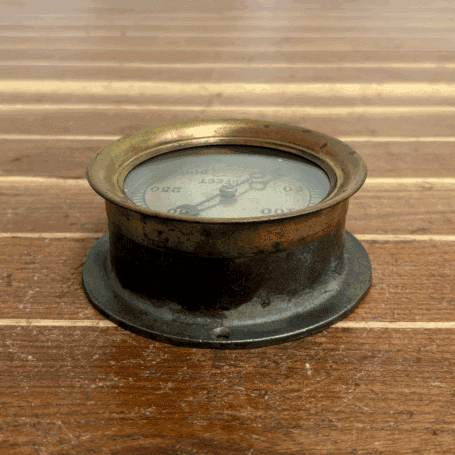 Vintage Ashcroft Pressure Gauge (6) top view of an aged gauge resting on a wood surface.