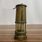 vintage mining lamp side view showing riveted brass body