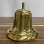 Side view of vintage brass ship bell with visible wear and patina