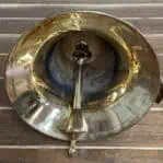 Solid brass ship bell with clapper visible from bottom angle