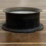 Side view of vintage brass pressure gauge with dark patina