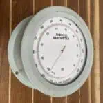Top-down view of round green barometer placed on wood surface