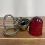 Disassembled view of weathered brass wall sconce with red globe