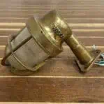 Brass wall sconce with ribbed globe mounted on wood surface