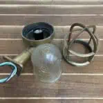 Disassembled parts of brass wall sconce with ribbed globe