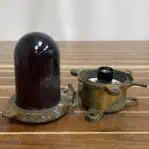 Salvaged red nautical ceiling light disassembled on wood surface