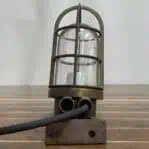Close-up of nautical light with cage and junction box wiring
