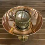 top view of vintage brass ribbed globe pendant light with copper rain cap installed
