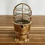 Close-up of nautical fixture with c;ear glass and aged brass finish