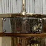 Close-up of data plate on brass nautical fixture body