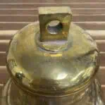 Brass bell top mounting block detail with surface wear