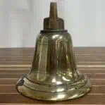 Side angle of weathered brass ship bell with visible patina