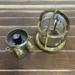Brass nautical ceiling light disassembled showing socket and glass housing