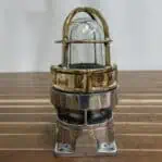 Brass and aluminum marine post light on wood table with polished finish