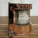 Side profile showing nautical lantern's glass lens and copper housing
