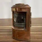 Side angle of copper navigation light showing Fresnel lens and patina