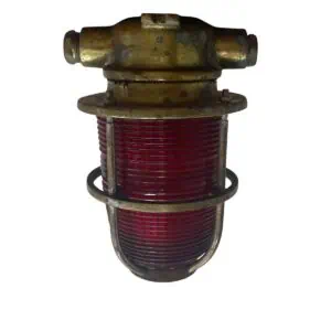 vintage marine light front view with red ribbed plastic lens and solid brass cage
