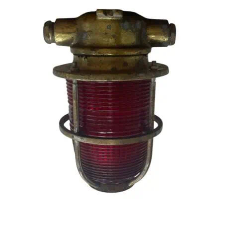 vintage marine light front view with red ribbed plastic lens and solid brass cage