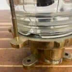 Detail of brass nautical deck light showing chipped section of the Fresnel glass lens