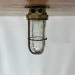 ship passageway light mounted view showing brass body and cage